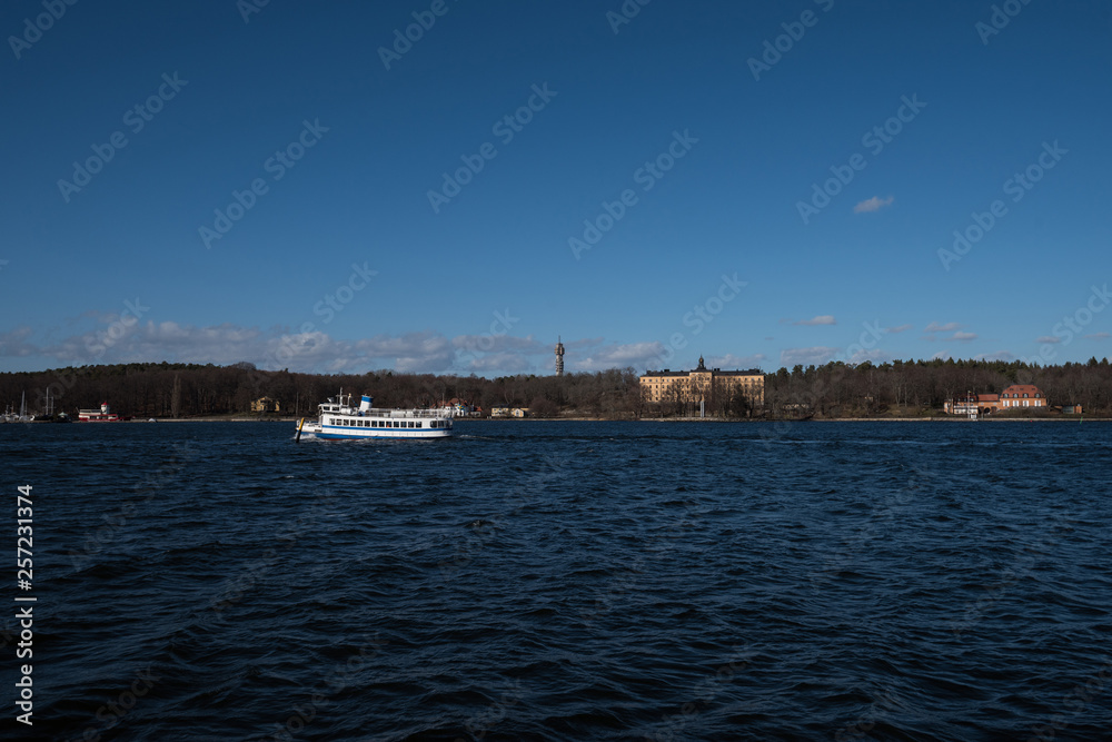 A sunny spring day in Stockholm, view over a pier with boats and birds at the city and old town