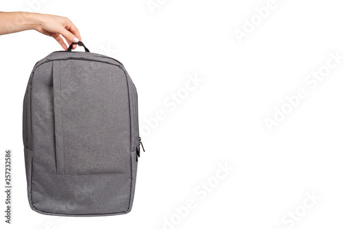 Hand with gray textile school bag, city street backpack