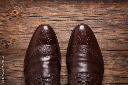 Men's shoes on the wooden floor top view. A pair of men shoes close-up on a wooden background.
