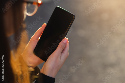Close-up of female hand using modern smart phone outdoor