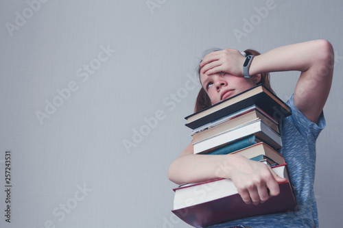 Weary young girl with books. Exams at school. Education.