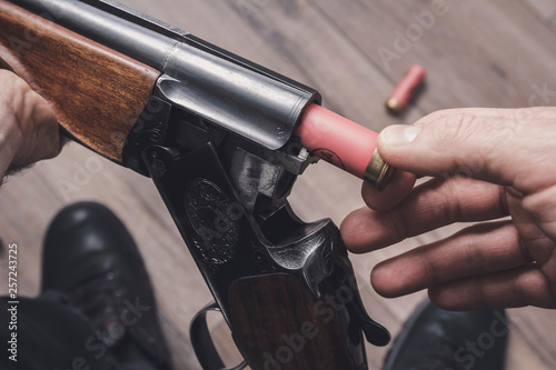 A man charges a double-barreled rifle with hunting cartridges