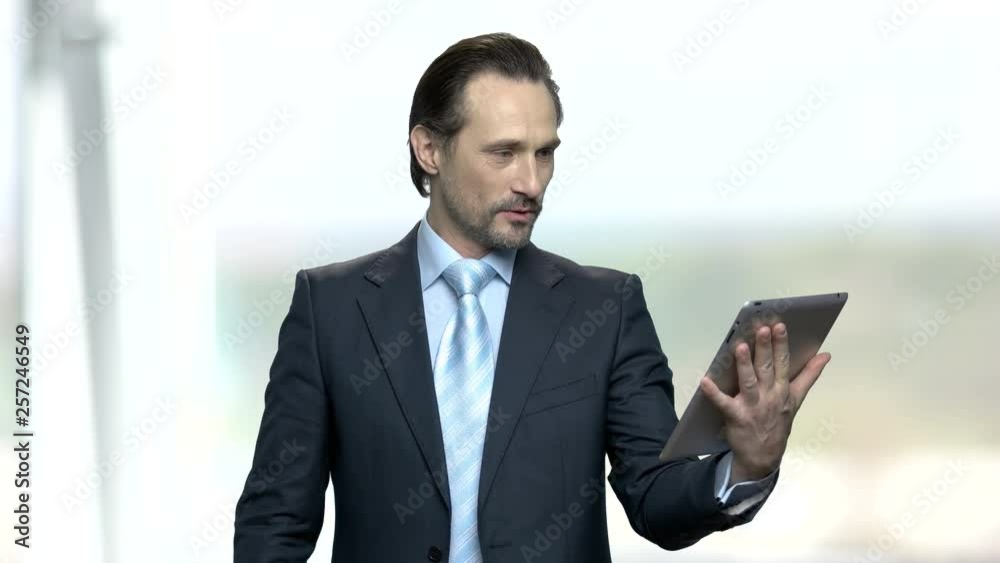 Happy businessman using digital tablet. Smiling caucasian businessman having video chat with family during break. People, modern technology, internet communication. Happy businessman using digital tablet. Smiling caucasian businessman having video chat with family during break. People, modern technology, internet communication.