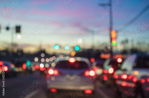 Blurred bokeh urban traffic background with cars and electric poles against sunset sky