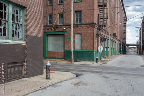 Vintage street scene with abandoned red brick warehouses in a depressed industrial area