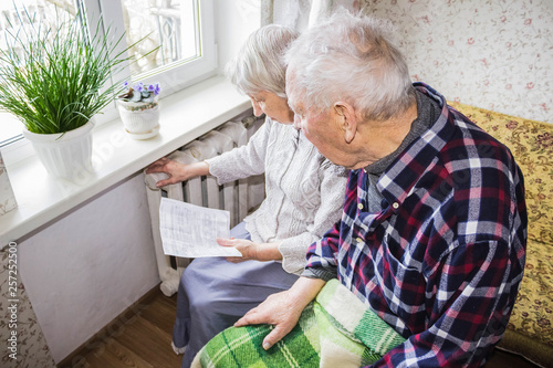 Woman holding cash in front of heating radiator. Payment for heating in winter. Selective focus.