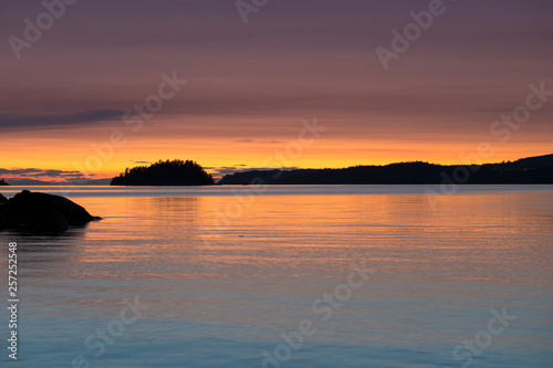 Stunningly beautiful sunsets of rocky beaches and mountains in beautiful British Columbia's Howe Sound on Bowen Island. © Jason