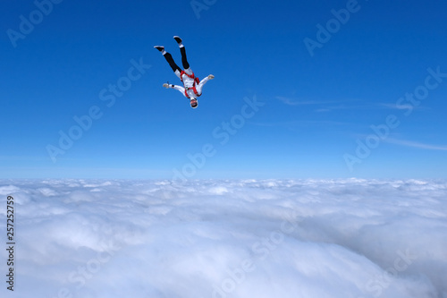 Skydiver is going to dive into the clouds.