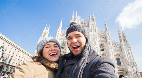 Funny couple taking self portrait in Duomo square in Milan. Winter traveling, Italy and relationship concept