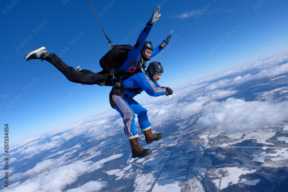 Tandem skydiving. Two guys are having fun in the sky.