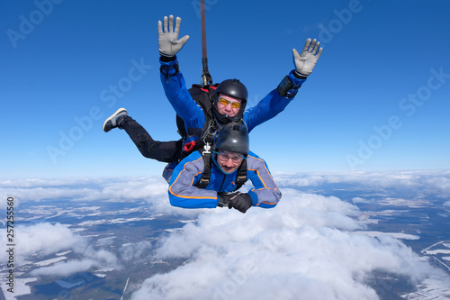 Tandem skydiving. Two guys are having fun in the sky.