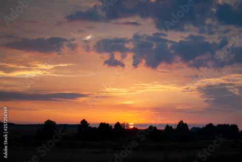 View of a Beautiful Sunset and Sky with dramatic clouds over a Silhouetted Land Horizont. © Анна Зарубина