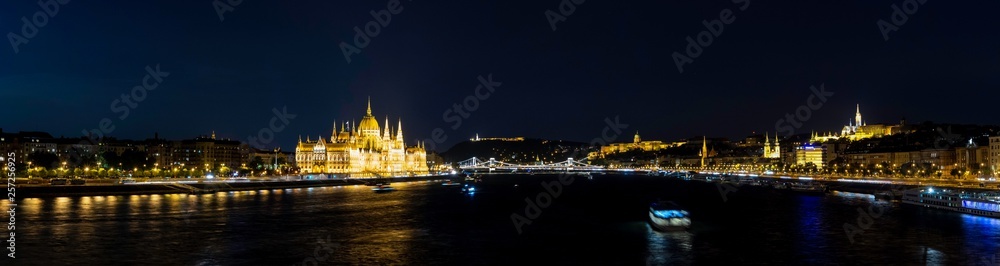 Panoramic night view of the Danube River as it passes through Budapest along with the Parliament, the Cathedral, the Fishermen's Bastion, the Buda Castle-Palace, the Chain Bridge and the Fortress,
