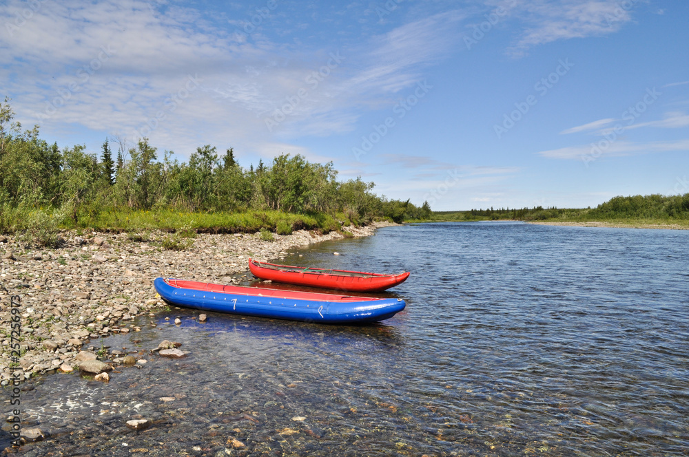 Two inflatable canoes on the shore of North river. Two inflatable canoes on the shore of North river.