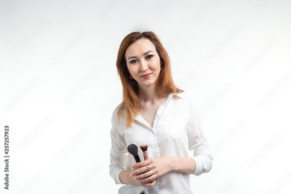 Makeup artist, beauty and cosmetics concept - Korean female make-up artist with makeup brushes on white background Makeup artist, beauty and cosmetics concept - Korean female make-up artist with makeup brushes on white background