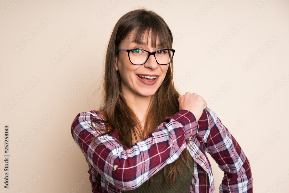 Young woman on ocher background celebrating a victory