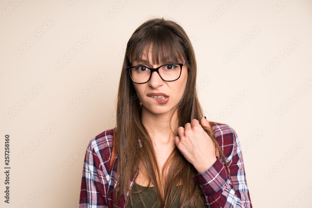 Young woman on ocher background having doubts and with confuse face expression Young woman on ocher background having doubts and with confuse face expression
