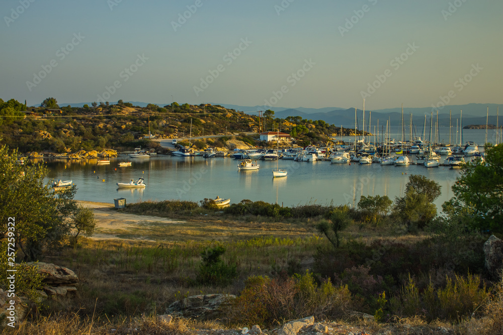 calming landscape with sea bay and many yachts on quiet water surface in Greece outdoor picturesque environment of Aegean waterfront coastline , tourism and rest concept