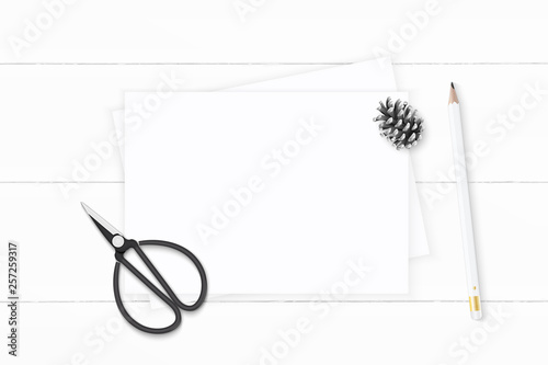 Flat lay top view elegant white composition paper pine cone pencil and vintage metal scissors on wooden background © Phoebe Yu