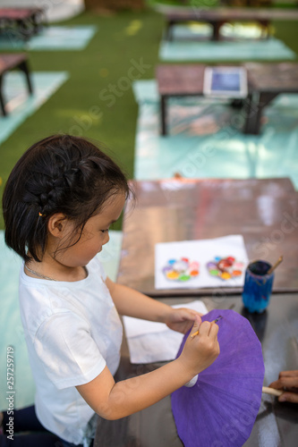 Asian kid drawing on mulberry paper umbrella, work with art craft