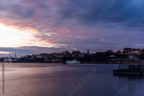 A red, colorful sunrise on the sea in the harbor of Stockholm in winter with the backdrop of the Old Town with the sign "To the Ferry" in Swedish - 4