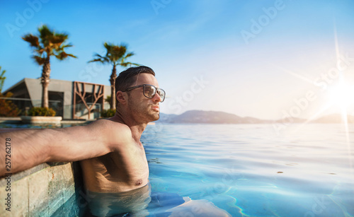 Portrait of a muscualar man relaxing in a tropical, hot water photo