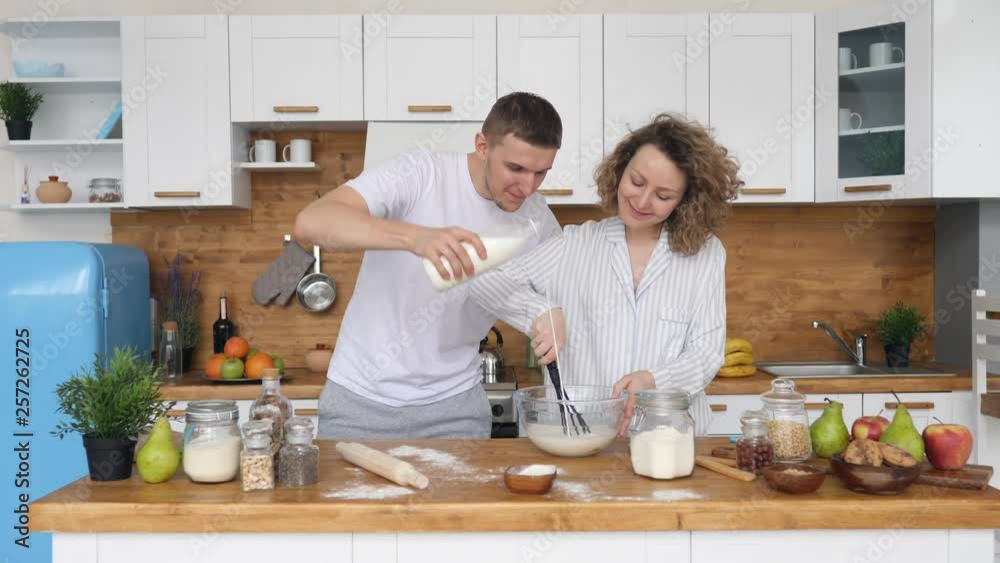 Happy Young Couple Cooking Together In The Kitchen At Home. Happy Young Couple Cooking Together In The Kitchen At Home.