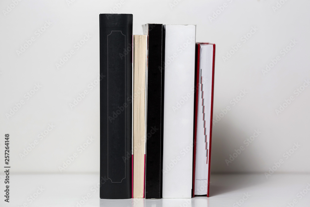 Fototapeta premium Reading books arranged on a white table. Background texture.