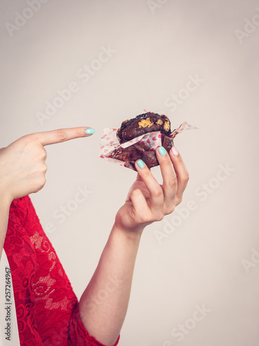 Woman holding chocolate cupcake muffin