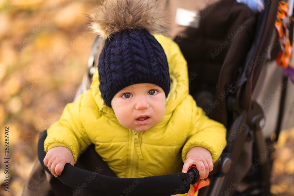 Baby 10 months in stroller, autumn hat with pompon Baby 10 months in stroller, autumn hat with pompon