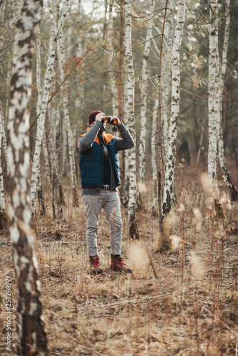 Man with binoculars in the forest