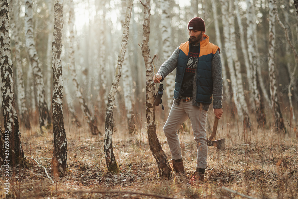 Man with hatchet in the forest