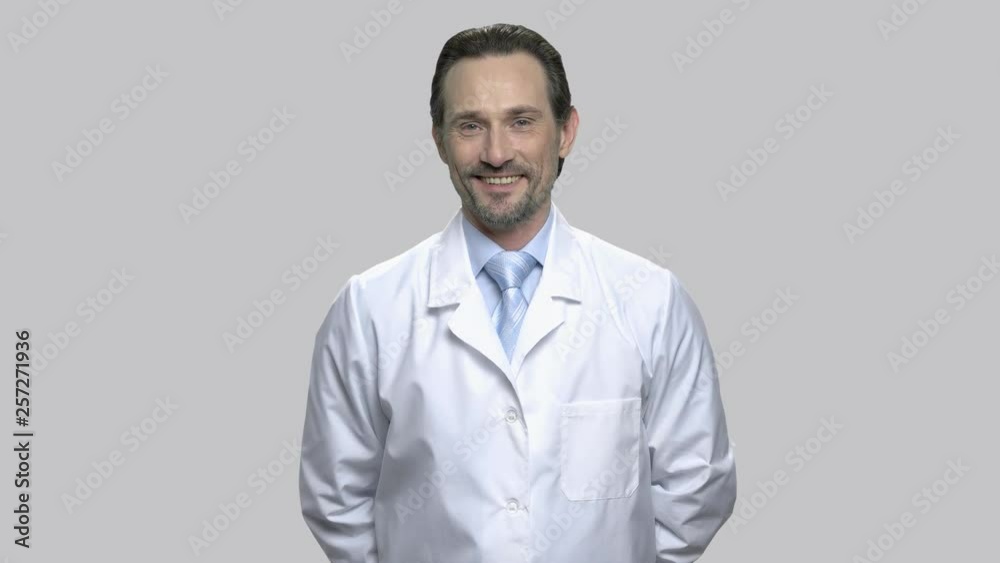 Smiling mature scientist looking at camera. Cute cheerful doctor folded his hands behind his back. People, occupation, lifestyle. Smiling mature scientist looking at camera. Cute cheerful doctor folded his hands behind his back. People, occupation, lifestyle.