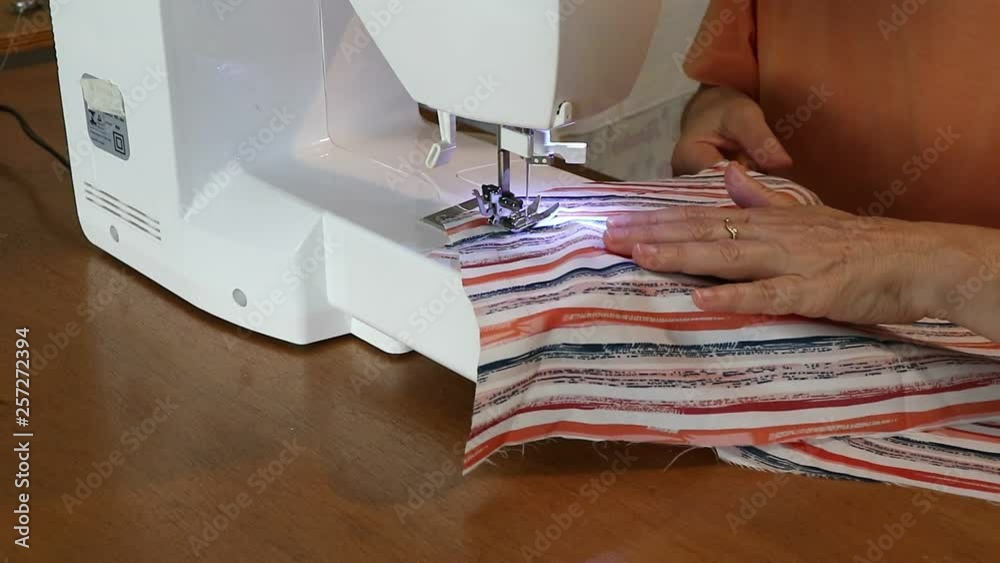 Costurando roupas feitas artesanalmente em seu ateliê