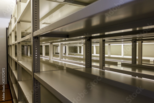 Empty metallic bookshelves with illuminated background