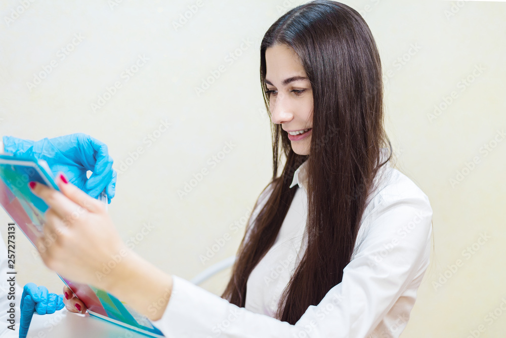 young girl smiling at the reception at the doctor. the patient fills out a questionnaire at the clinic. young girl smiling at the reception at the doctor. the patient fills out a questionnaire at the clinic.