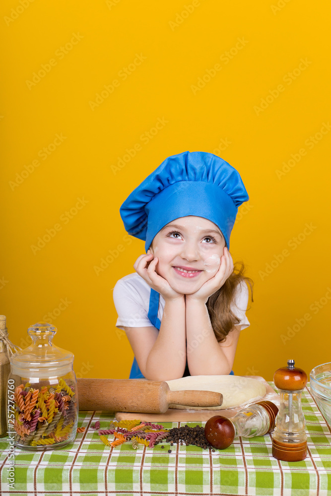 Little baker. Pretty cook kneads dough Little baker. Pretty cook kneads dough