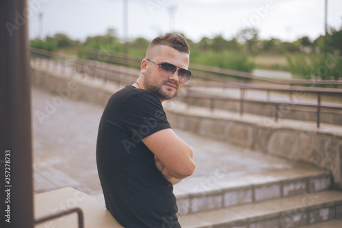 young handsome man in sunglasses poses © Artem