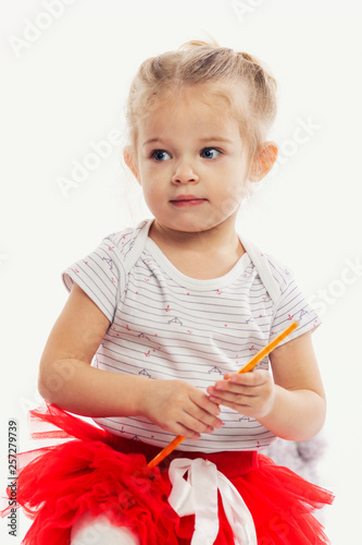 Cute little girl with pencils for drawing in hands. White background.