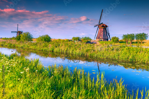 Rustic wooden windmills at sunset in Kinderdijk museum, Netherlands, Europe