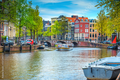 City skyline with water canal and tourist boats, Amsterdam, Netherlands