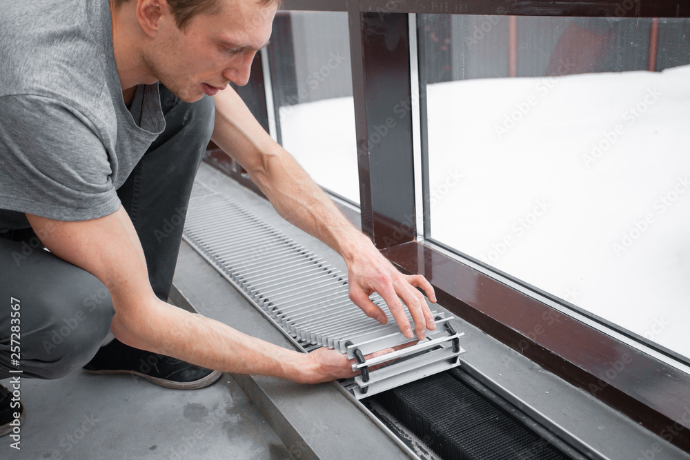 Fototapeta premium Warm floor. Heating system. Instalaltion of heating convector built into the concrete floor. Repair and renovation in house. Comfort climate at home..