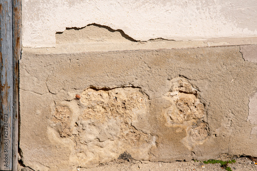 destroyed plaster on a house wall which falls off