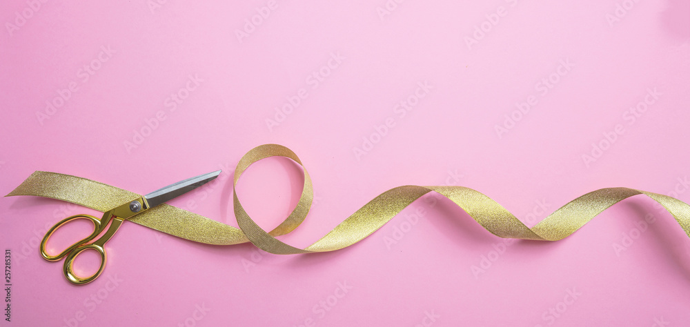 Gold scissors and golden ribbon, pink background, banner Gold scissors and golden ribbon, pink background, banner