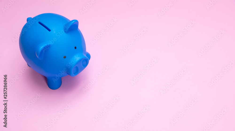 Piggy bank blue color against pastel pink background