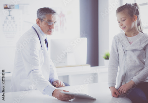 Portrait of a cute little girl and her doctor at hospital