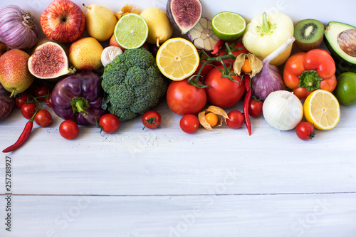 Various fresh vegetables and fruits on a wooden background, top view, copy space.