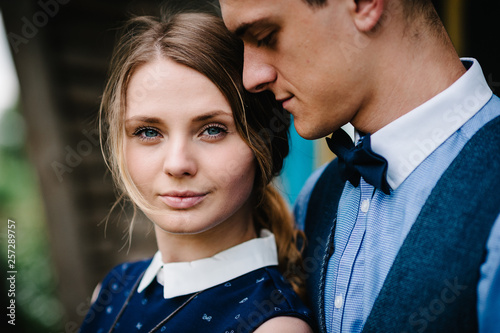 The face of young people. A young couple standing, hugging on the background nature. Close up. headshot, half length. Make-up and look at the camera.
