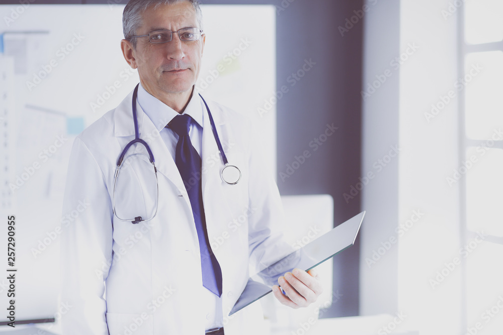 Male doctor writes notes on the clipboard in the hospital Male doctor writes notes on the clipboard in the hospital
