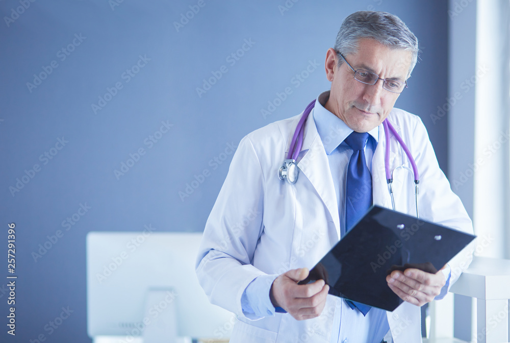 Male doctor writes notes on the clipboard in the hospital Male doctor writes notes on the clipboard in the hospital